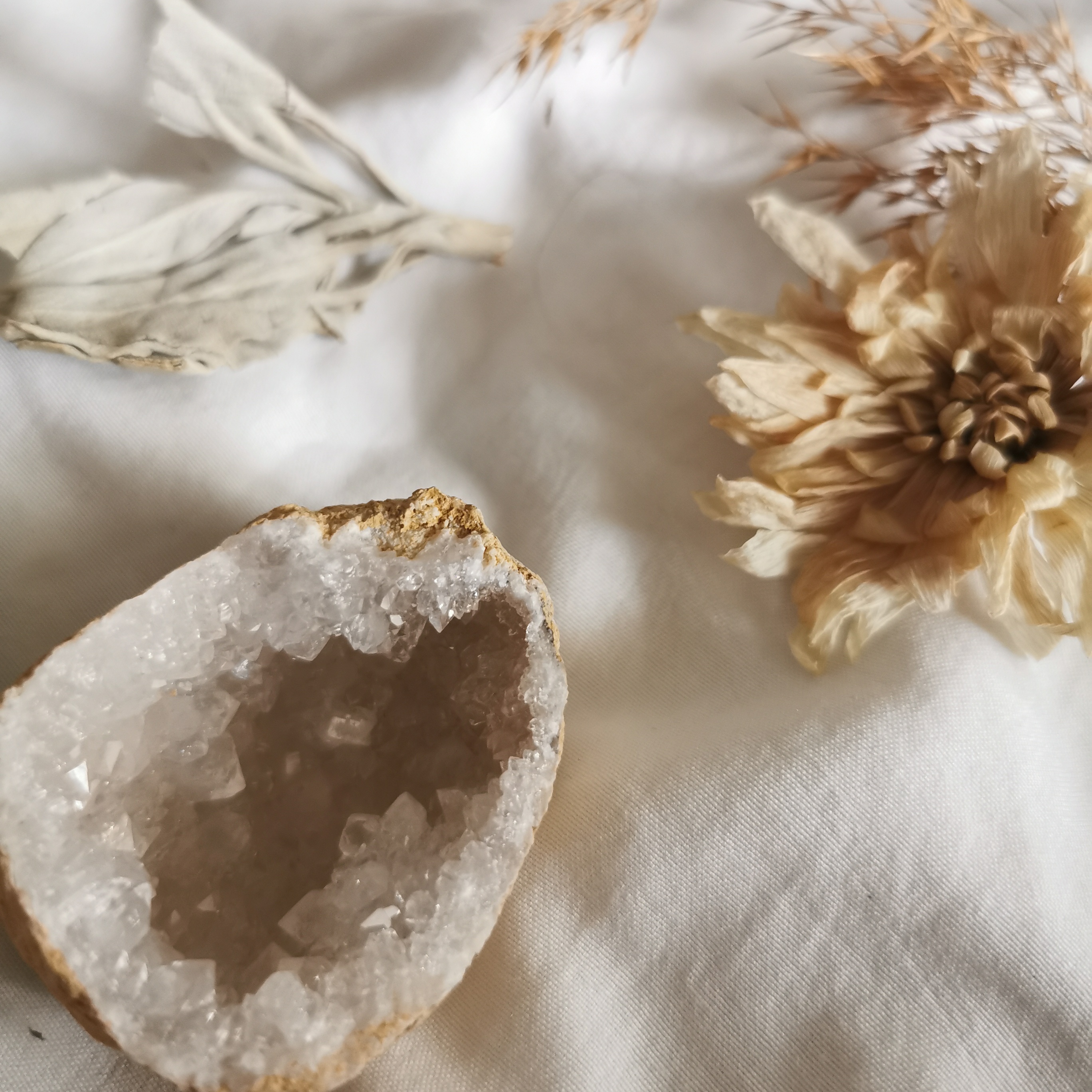 cristal de roche sur tissue en lin avec fleur séchée et sauge blanche