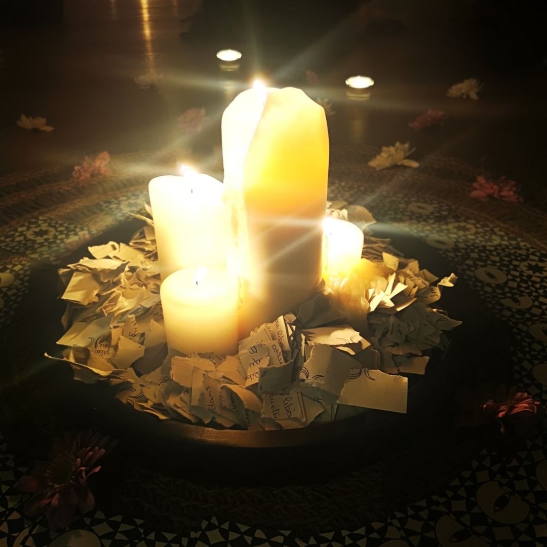 Rituel de libération avec bougies et intentions brûlées lors d’un cercle de femmes.