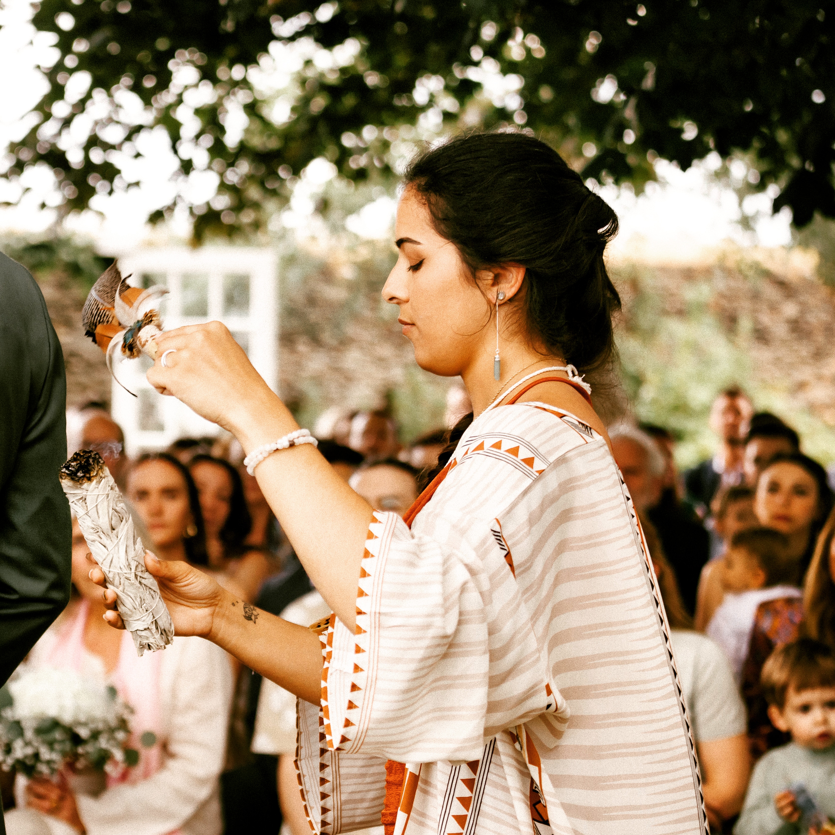 Debby, thérapeute holistique et femme médecine en Seine-et-Marne, guidant un rituel chamanique avec fumigation et plume lors d’une cérémonie spirituelle.